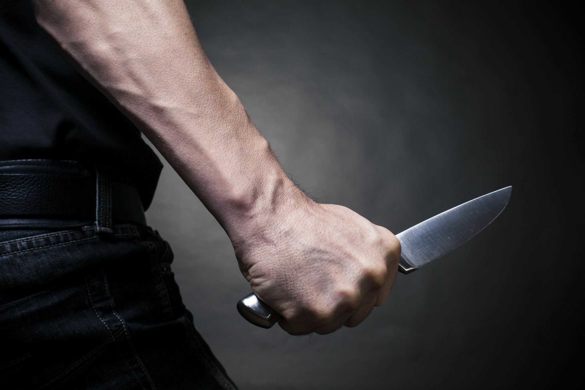 Человек угрожает ножом. Мужчинская рука с ножом.